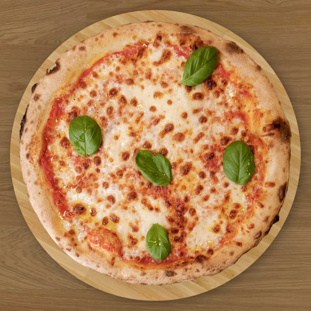 Margarita - Den enkle, ekte smaken av Italia – tomatsaus, fersk mozzarella og basilikum på en sprø, vedfyrt bunn. Perfekt balanse mellom friskhet og fylde.